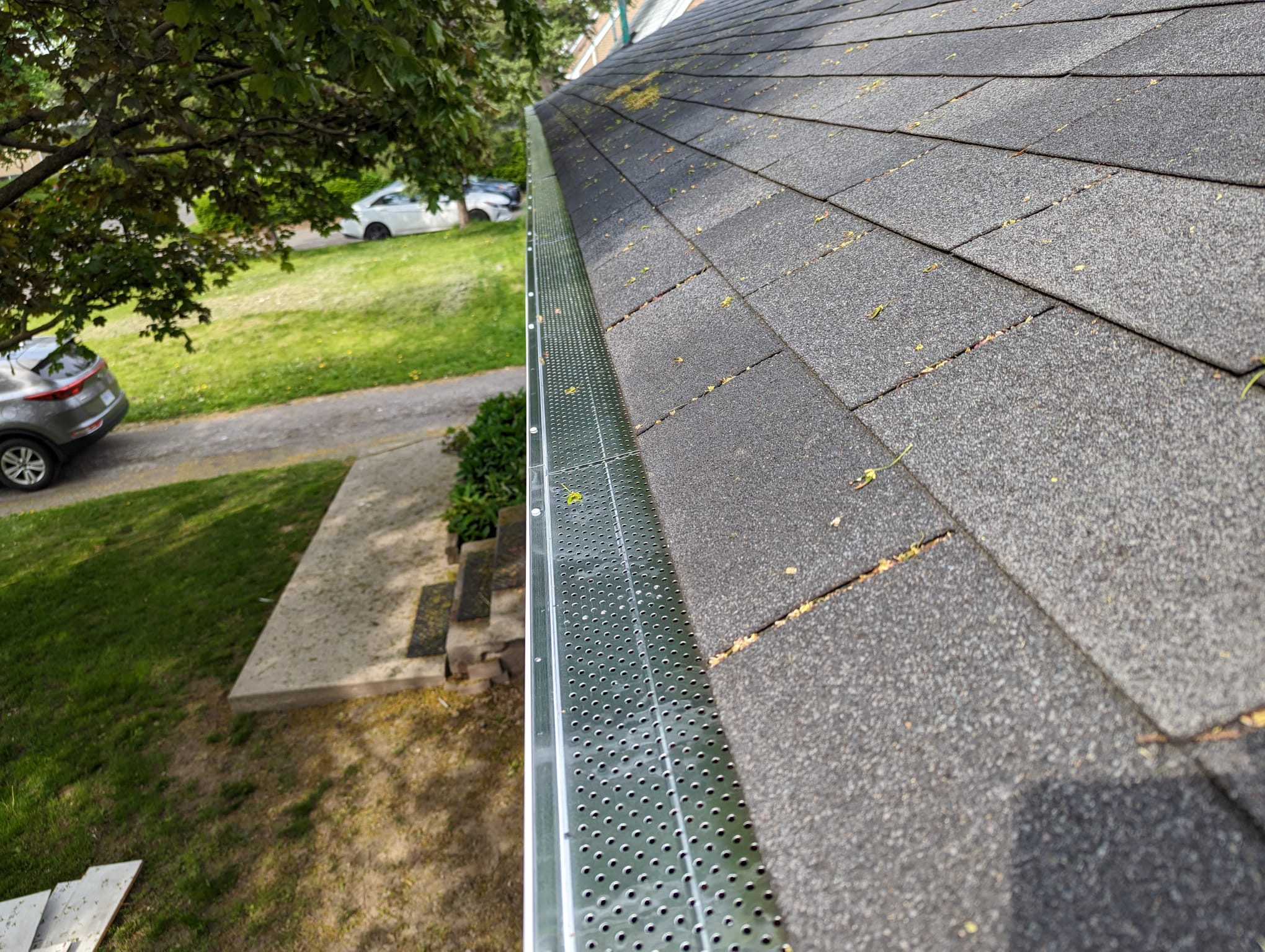 Installed gutter guard system on roof edge protecting gutters