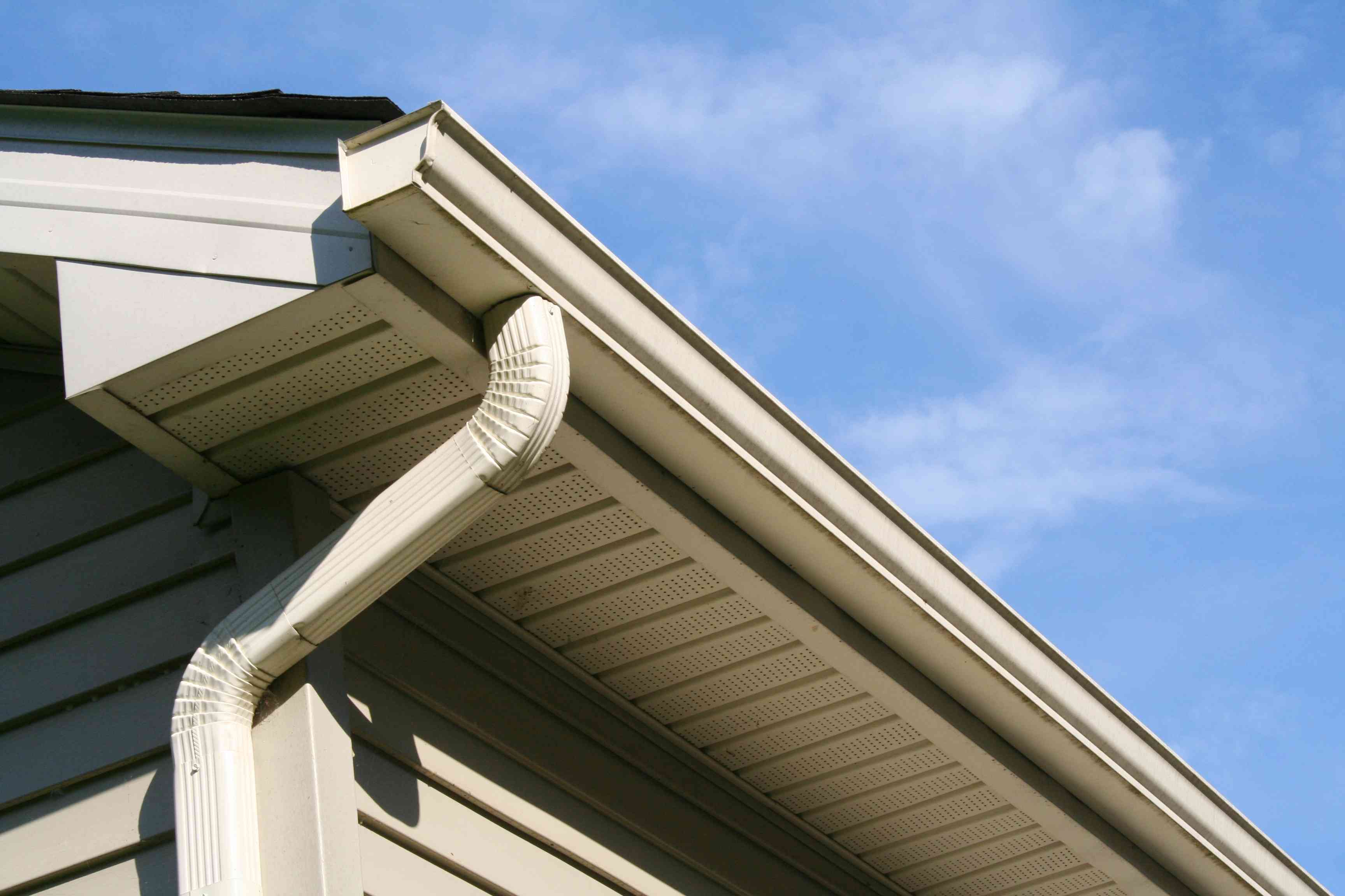 Installation crew fitting seamless gutters on a residential home
