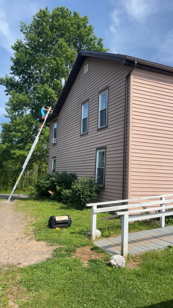 Installer on a ladder during gutter installation